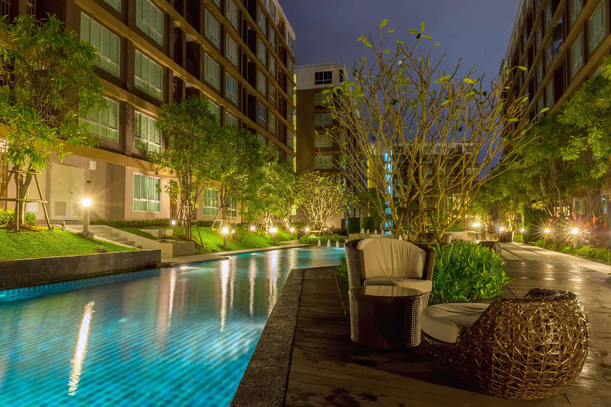 Modern residential apartment houses with swimming pool, at night